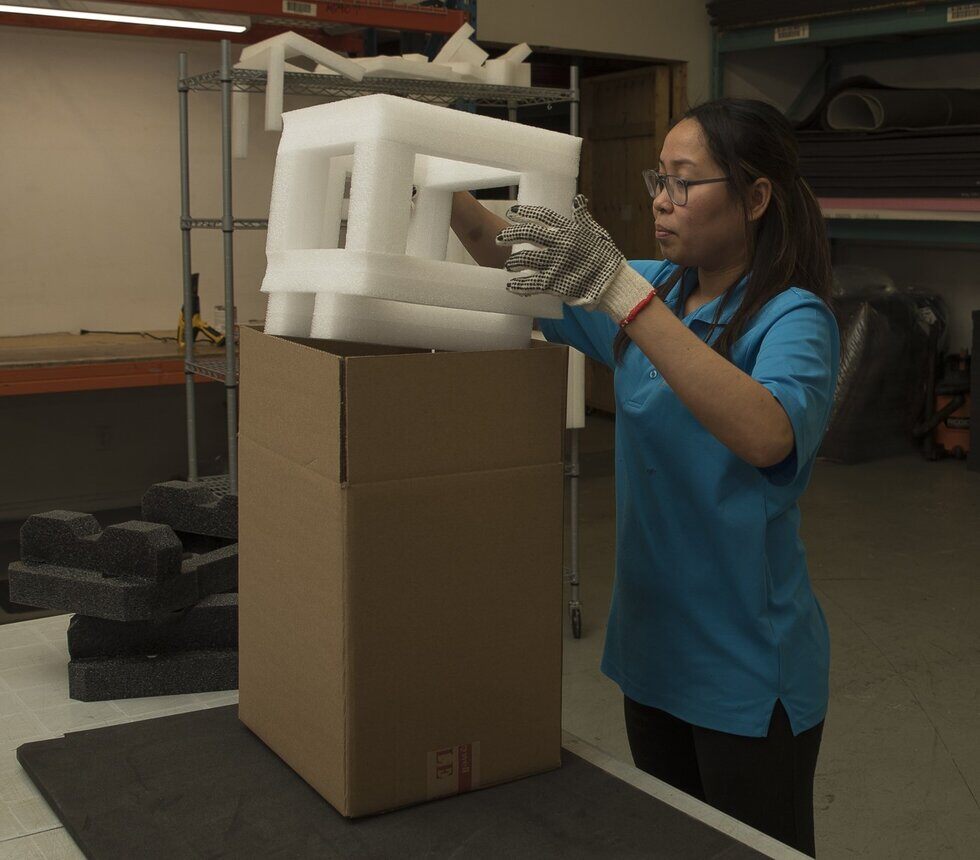 Female putting foam set inside cardboard box